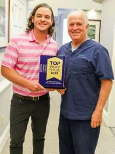Dr. Ayers and Brent Ayers holding Top Workplaces Award